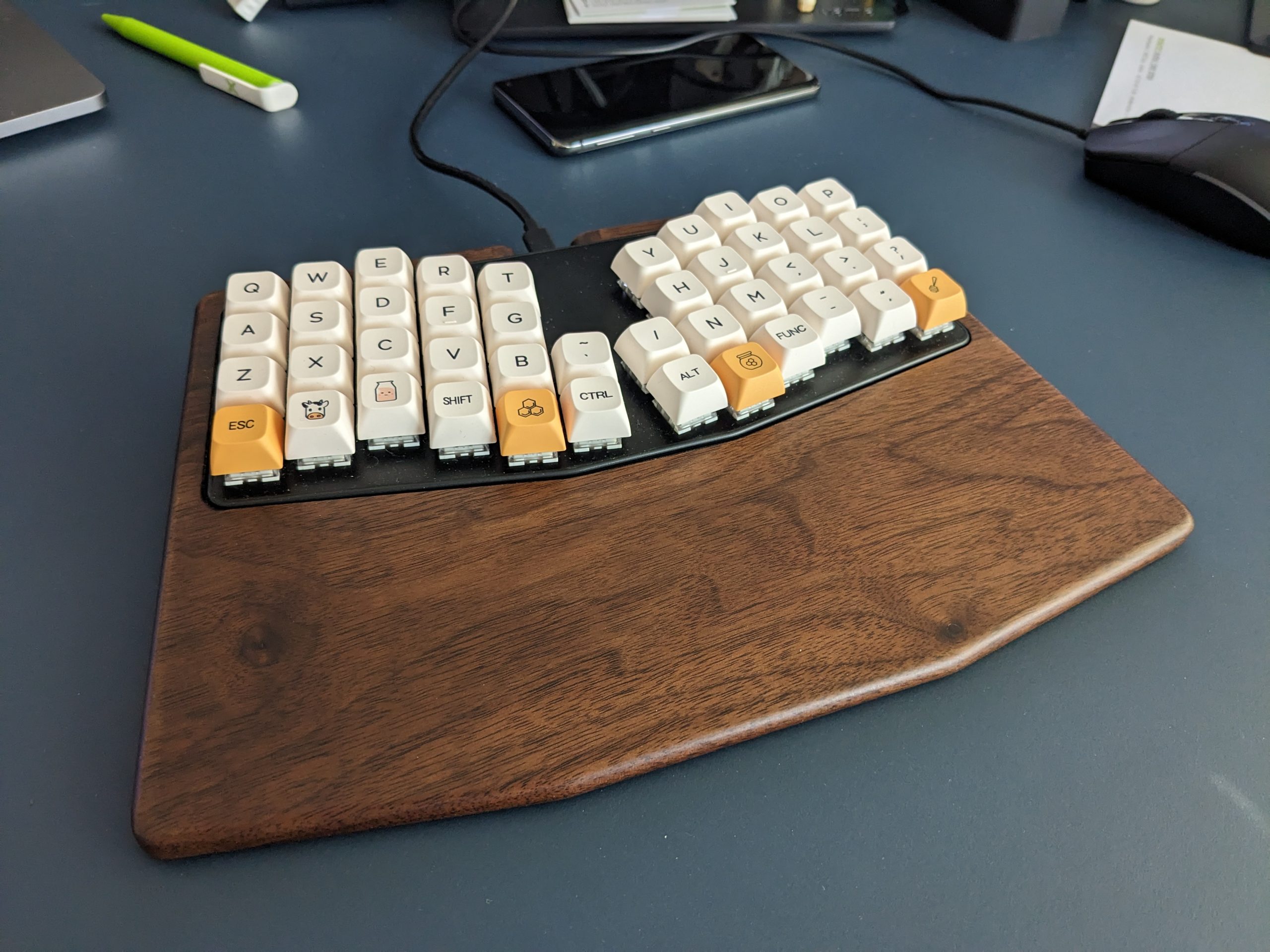 Atreus keyboard with changed key caps, and a walnut palm rest.